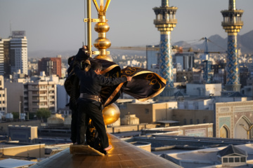 Servants change dome flag at Imam Reza (AS) shrine